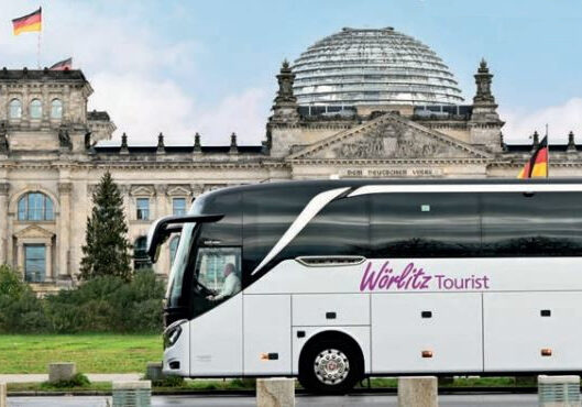 Bus WT Busreisen ab Berlin mit Wörlitz Tourist. Ein Bus steht vor dem Reichstag in Berlin.