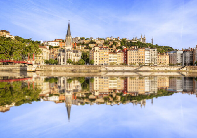 Busreisen nach Frankreich. Blick auf die Altstadt von Lyon, Frankreich, mit bunten Häusern, der Kirche Saint-Georges und Spiegelung in der Saône an einem klaren Tag.