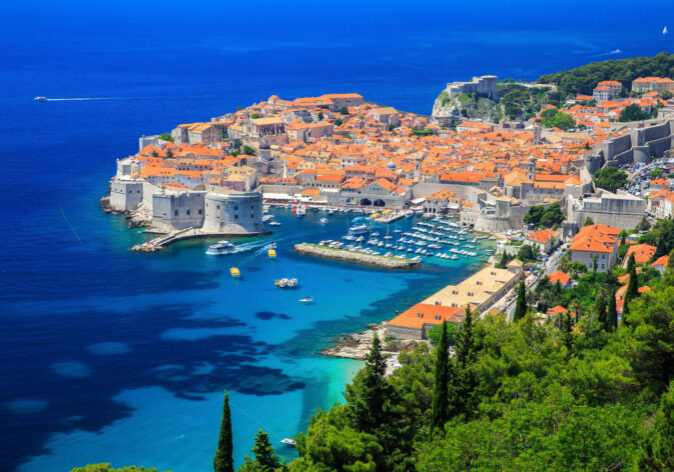 Dubrovnik-Kroatien-Reisen Blick auf die historische Altstadt von Dubrovnik während einer Busreise, mit den beeindruckenden Stadtmauern und dem azurblauen Adriatischen Meer im Hintergrund.
