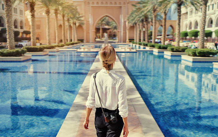 Frau mit Kamera spaziert durch die Innenstadt von Dubai